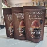 Three packages of Forest Feast peanut butter and milk chocolate dates on a white surface.