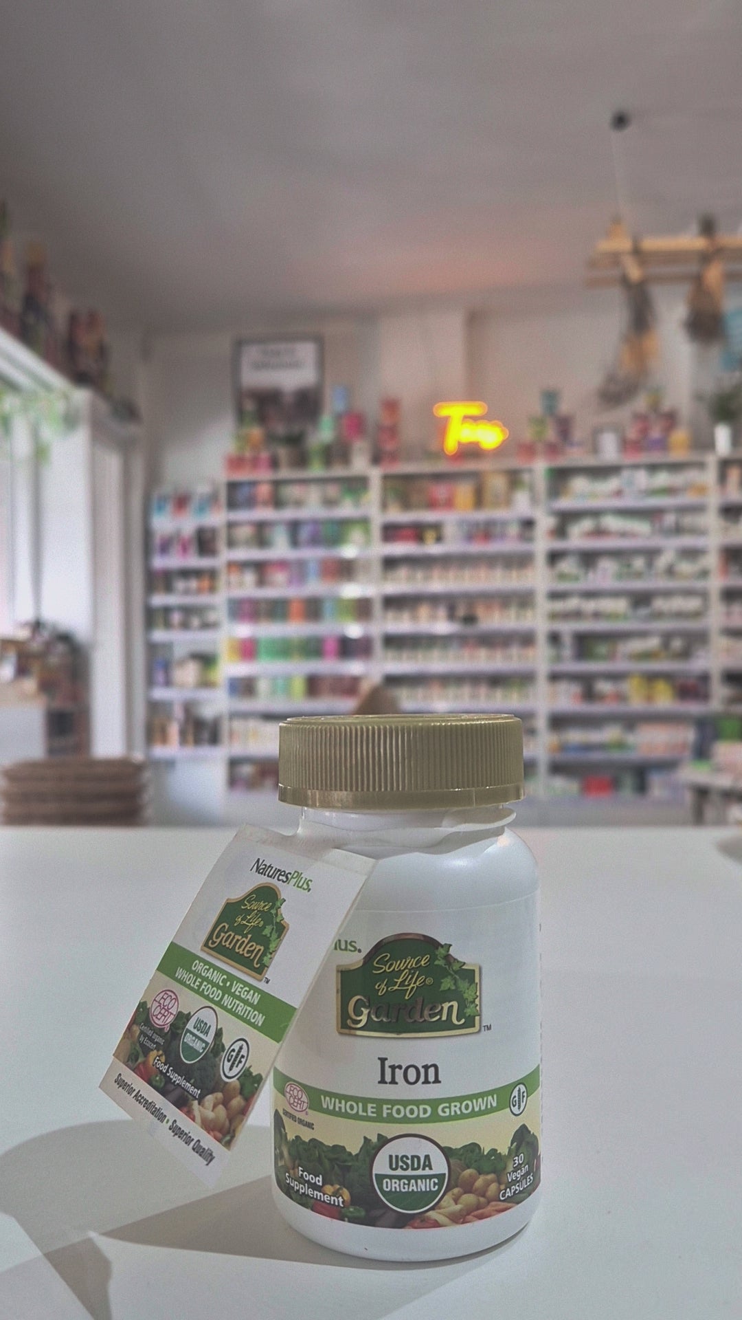A bottle of Nature's Plus Source of Life Garden Iron, certified organic iron whole food grown, with the USDA organic seal displayed, in a store setting, video 