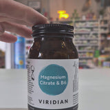 Bottle of Viridian Magnesium Citrate & B6 supplement on a white surface with a blurred store background.