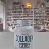 A bottle of Nature's Plus Collagen Capsules, labeled 'Collagen Peptides', indicating 120 capsules in the container. Collagen peptides supplement bottle on a table with a store interior in the background video