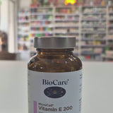 BioCare Vitamin E 200 supplement bottle on a table with a blurred background