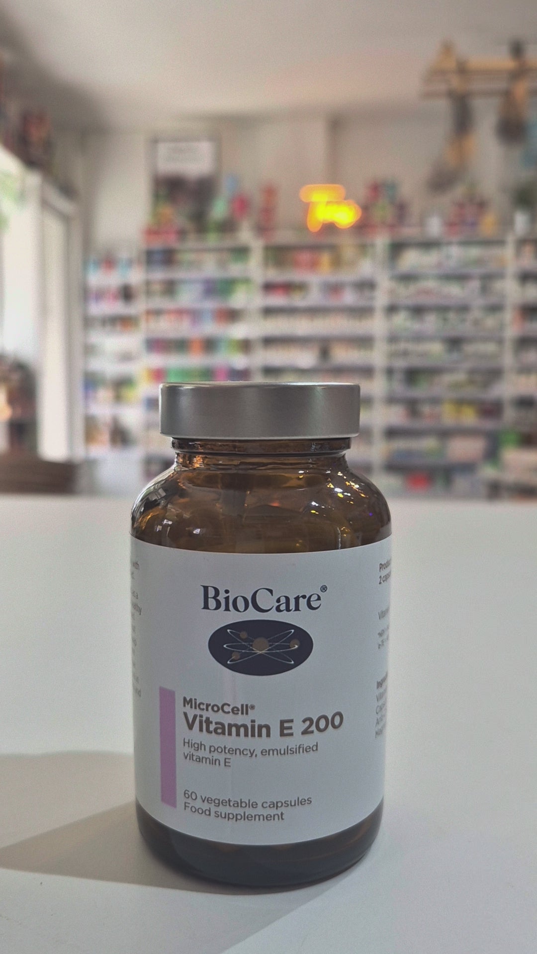 BioCare Vitamin E 200 supplement bottle on a table with a blurred background