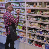 Nature's Plus Collagen Peptides in Berry Lemonade flavor, dietary supplement powder in a white container with pink and green text highlighting the product features. Man holding a container of NaturesPlus Collagen Peptides in a store setting