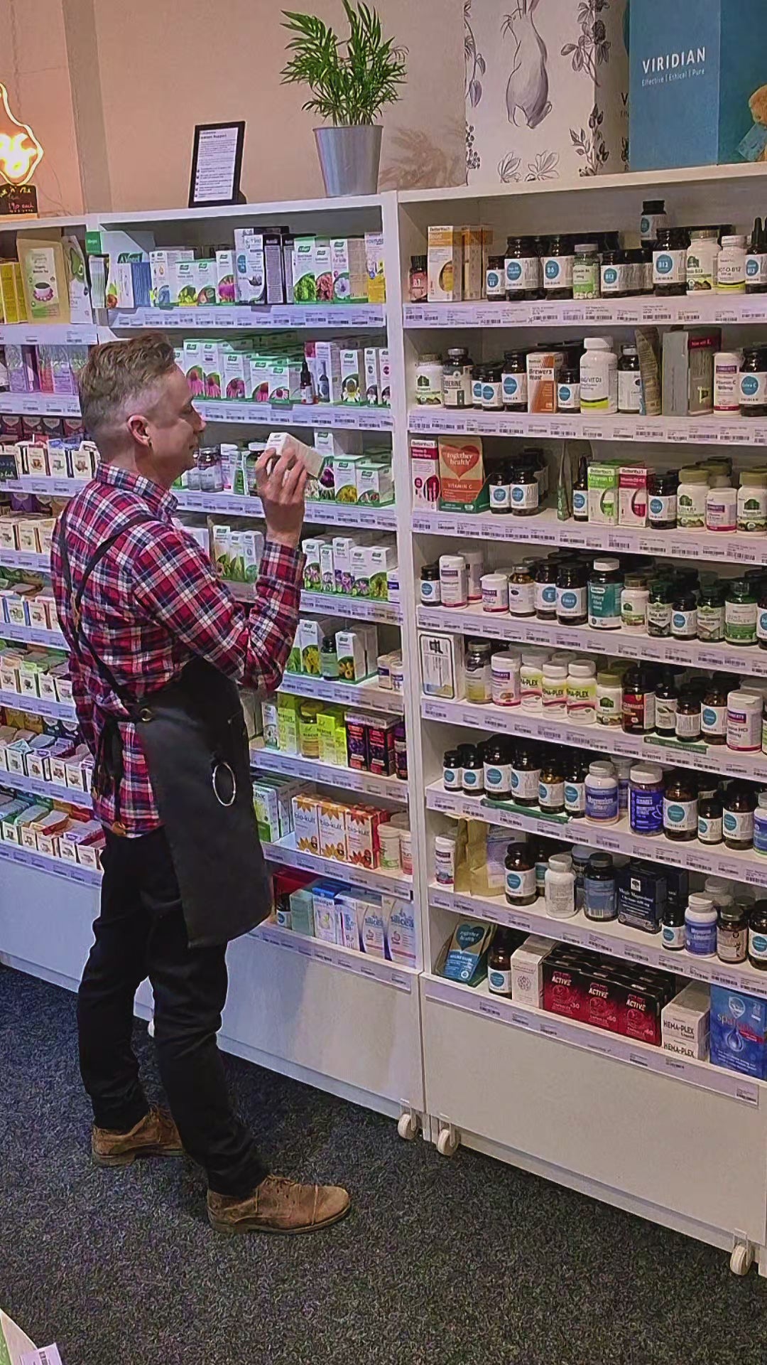 Nature's Plus Collagen Peptides in Berry Lemonade flavor, dietary supplement powder in a white container with pink and green text highlighting the product features. Man holding a container of NaturesPlus Collagen Peptides in a store setting