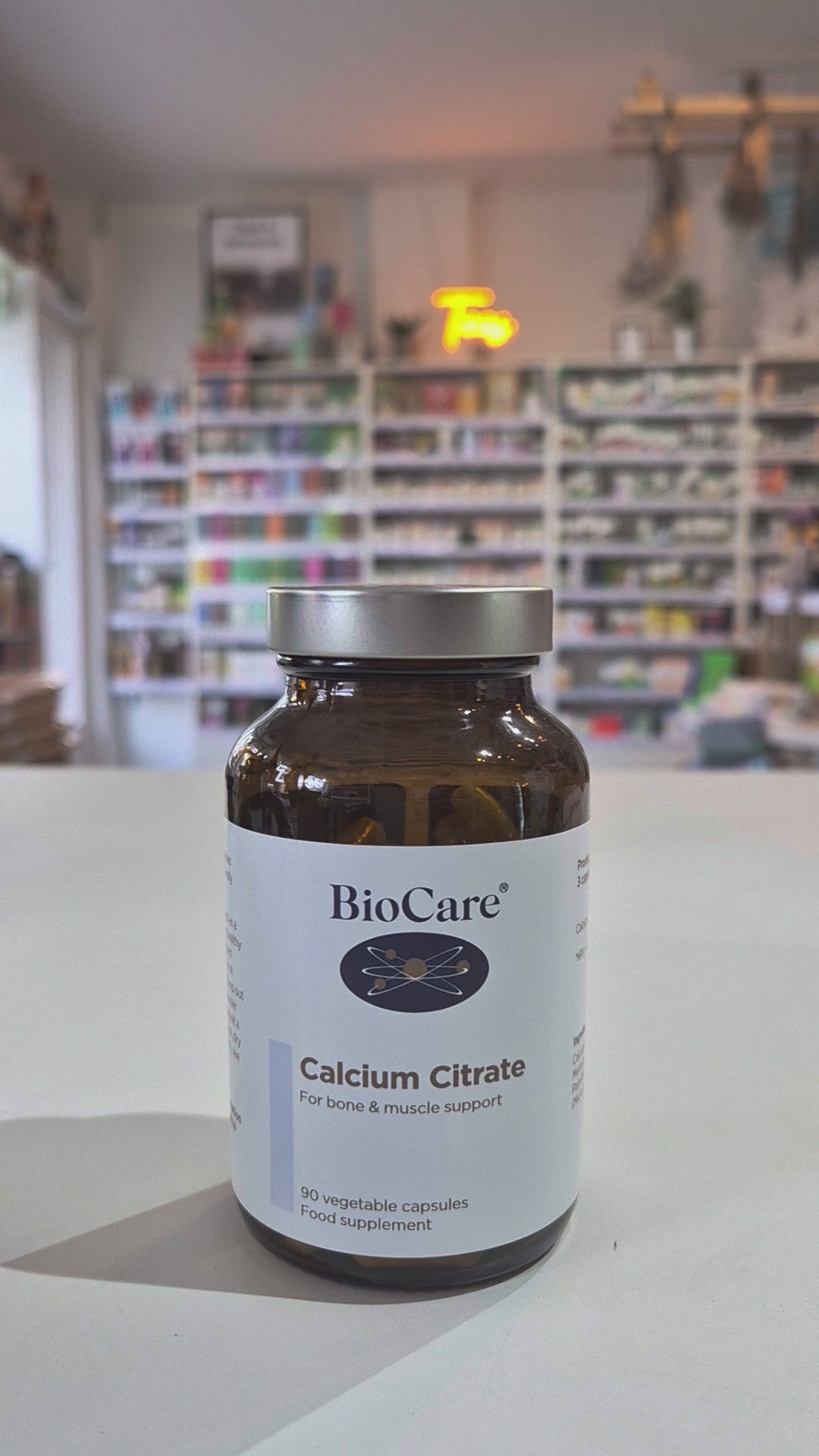 A bottle of Biocare Calcium Citrate containing 90 capsules for bone and muscle support in a shop setting video