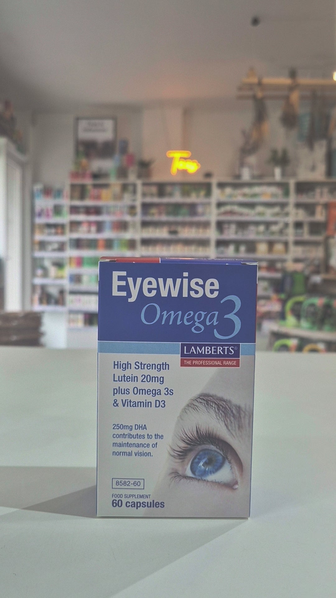 A box of Lamberts Eyewise Omega 3 supplements featuring an image of an eye and highlighting the product's benefits for maintaining normal vision video.