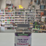 Nature's Truth Hair, Skin & Nails Gummies bottle on a white surface with a blurred store background video
