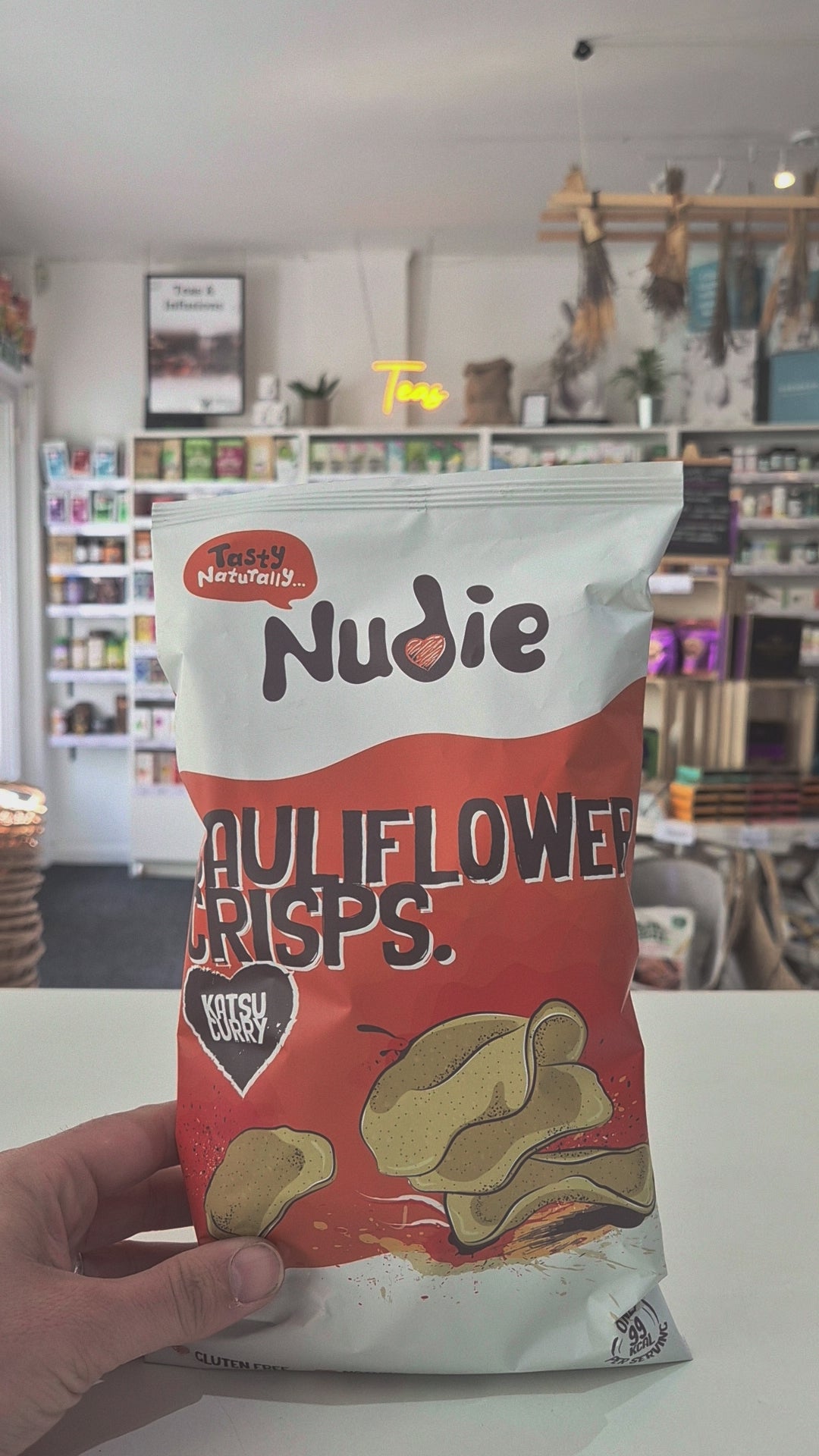 Nudie Katsu Cauliflower Crisps bag with a store interior in the background