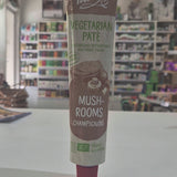 A tube of Tartex Vegetarian Pate Mushrooms on a white countertop with a blurred grocery store background.