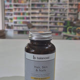 Supplement bottle labeled 'balanced' for hair, skin, and nails on a table with a blurred store background video