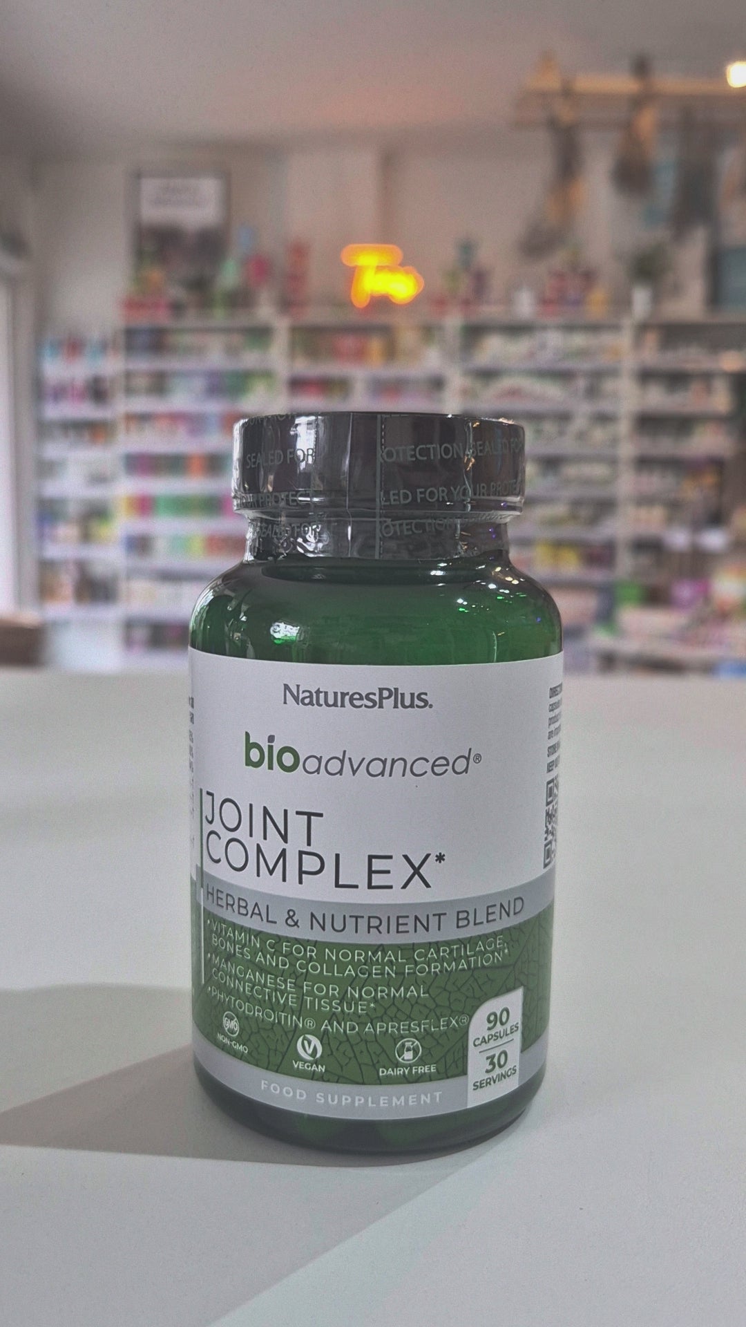 Bottle of NaturesPlus BioAdvanced Joint Complex on a table with a blurred store background