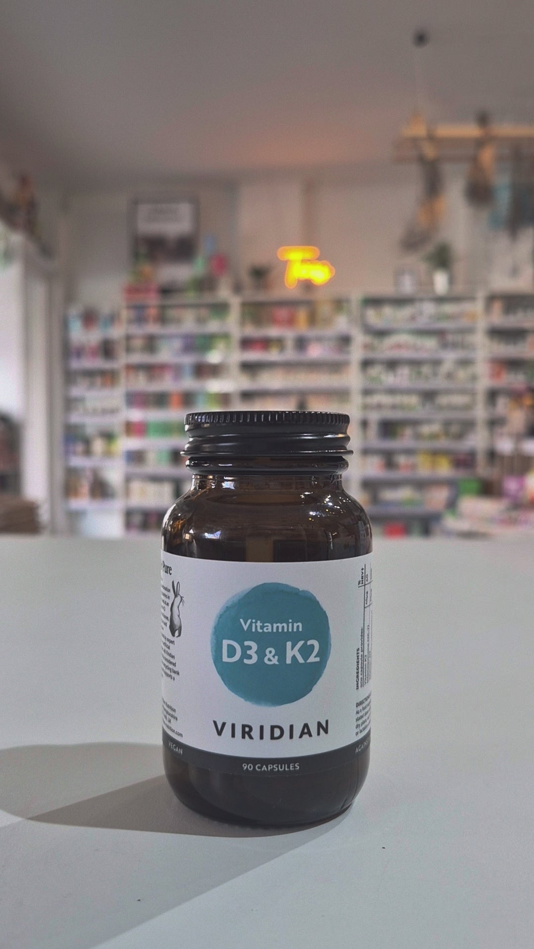 Vitamins D3 & K2 bottle with Viridian label on a shop background video