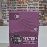 Purple Hunter & Gather supplement package with 'Restore' and 'Mixed Berry' text on a blurred indoor background. 