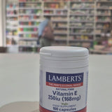 Lamberts Vitamin E supplement container on a table with a blurred background