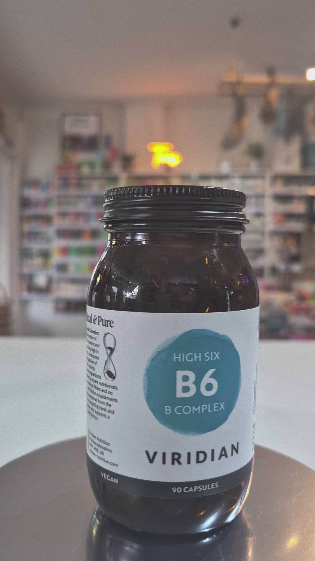 Jar of Viridian High Six B6 B Complex supplement on a counter with a blurred store background video