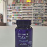 Blue bottle of Higher Nature Vitamin K2 on a light surface with a blurred background