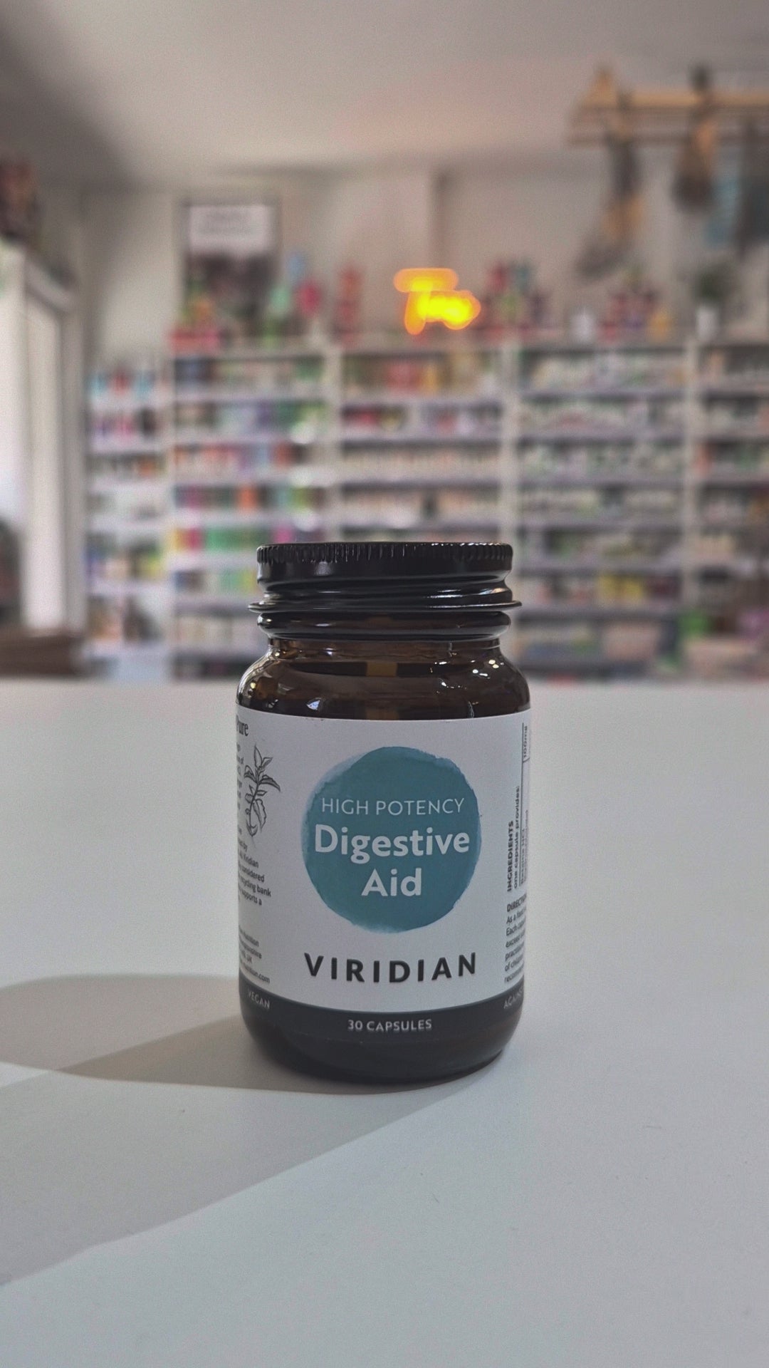 Bottle of Viridian High Potency Digestive Aid on a white surface with a blurred background