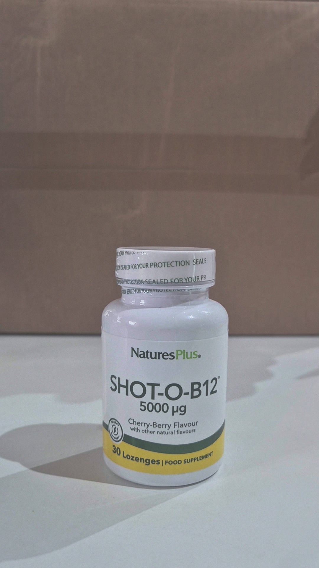 Nature's Plus Shot-O-B12 5000 Mcg lozenge in a white bottle with green and purple label, indicating wild berry flavour and dietary supplement category in a shop video