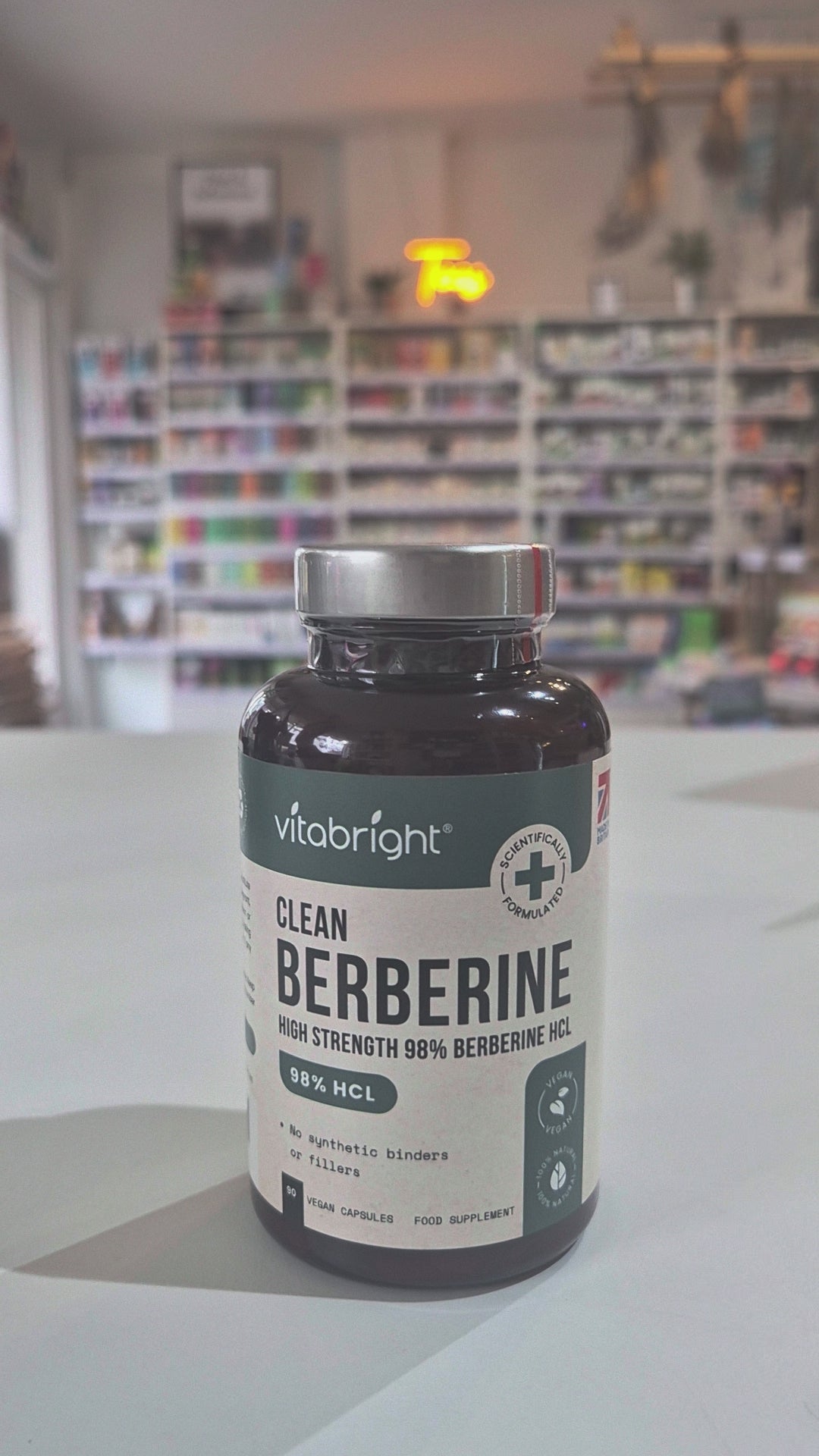Vitabright Clean Berberine supplement bottle on a table with a blurred background video. 