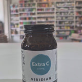 Brown supplement bottle labeled 'Extra C 550mg' by Viridian on a white surface with a blurred store background as a video