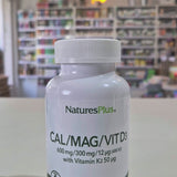 NaturesPlus Cal/Mag/Vit D3 supplement bottle on a table with a blurred store background video
