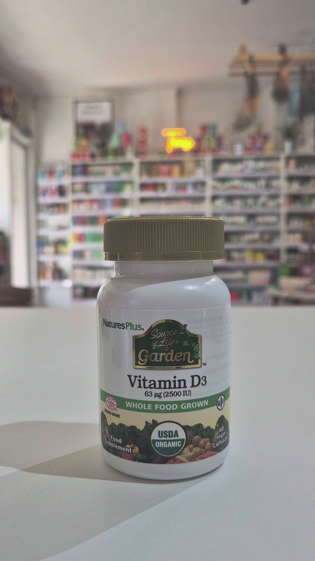 Nature's Plus Vitamin D3 supplement bottle on a white surface with a blurred background