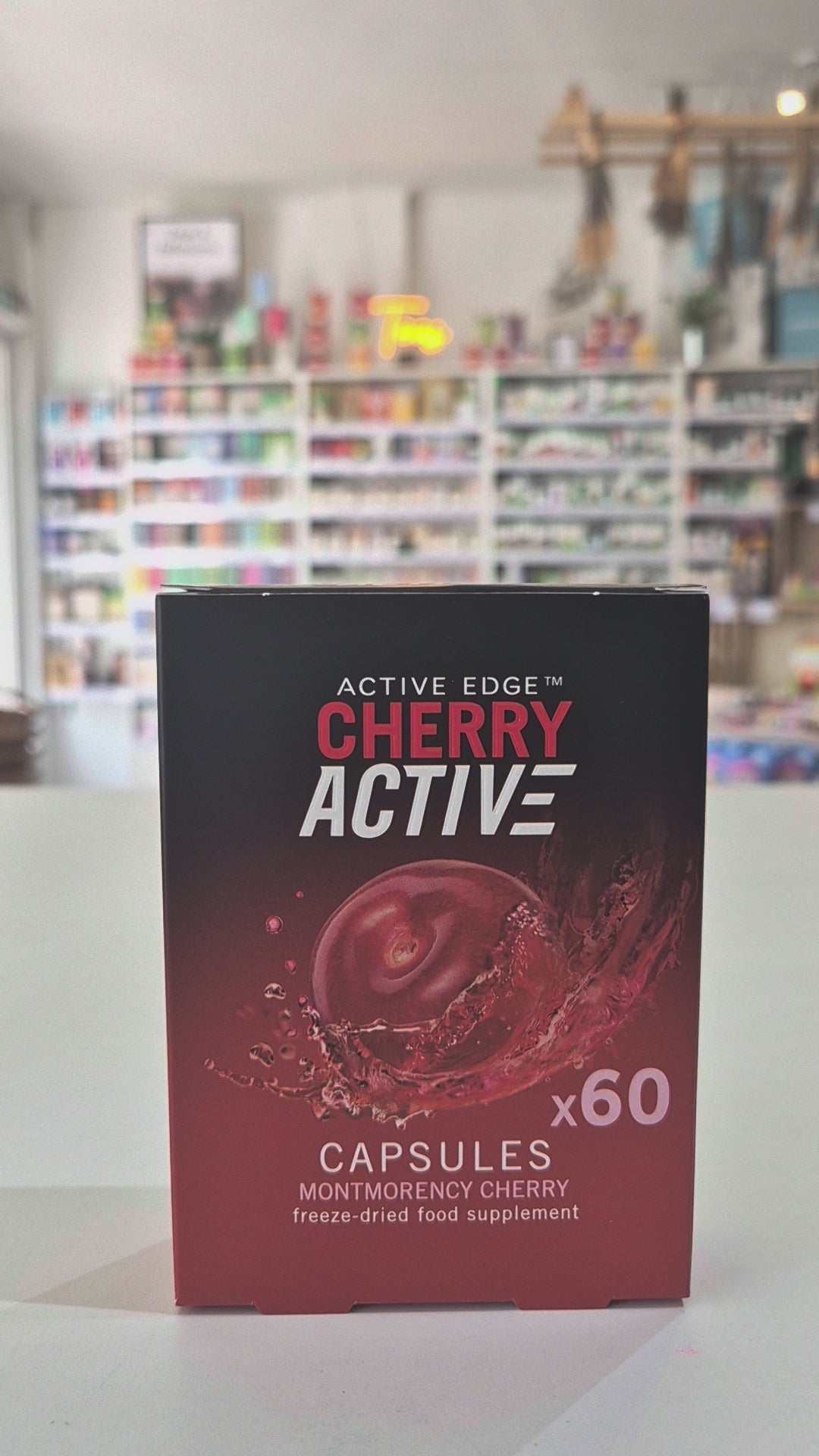 Box of ActiveEdge Cherry Active capsules with a cherry illustration on a blurred store background
