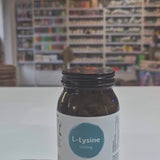 Bottle of Viridian L-Lysine supplement on a white surface with a blurred background