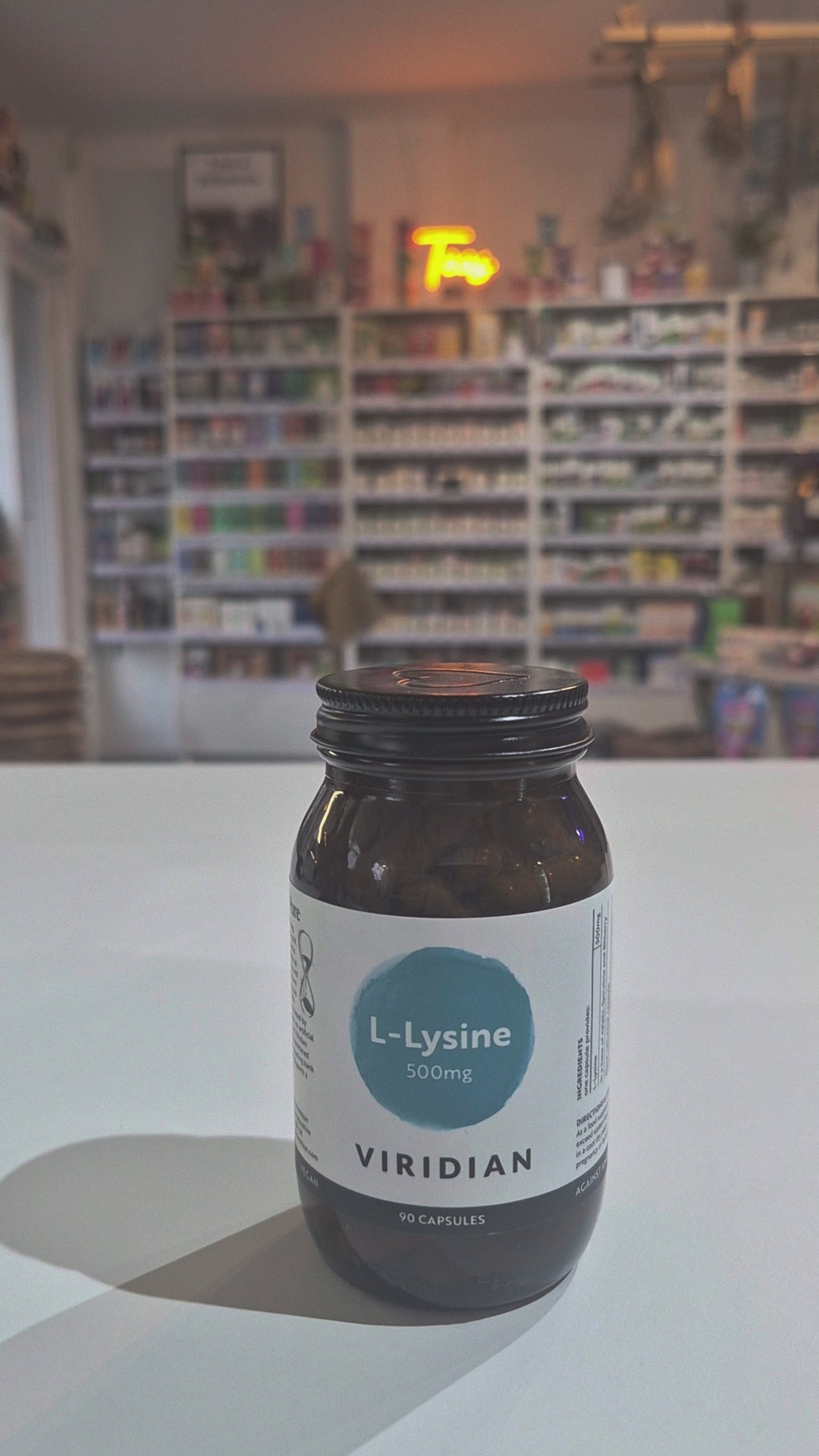 Bottle of Viridian L-Lysine supplement on a white surface with a blurred background