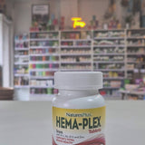 Bottle of Natures Plus Hema-Plex Tablets 42mg Elemental Iron, 30 capsules on a white surface with a blurred indoor background.