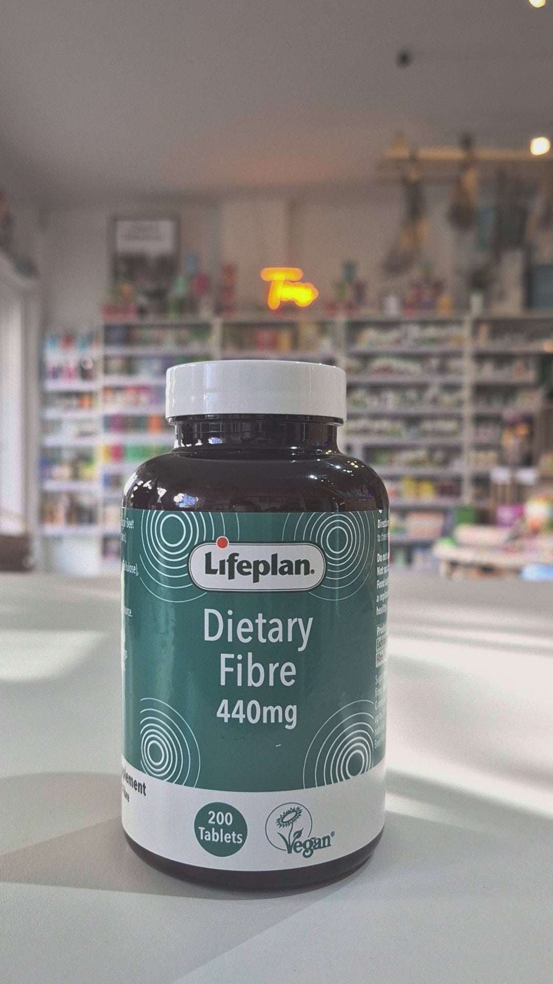 Lifeplan Dietary Fibre 440mg supplement bottle on a counter with a store background