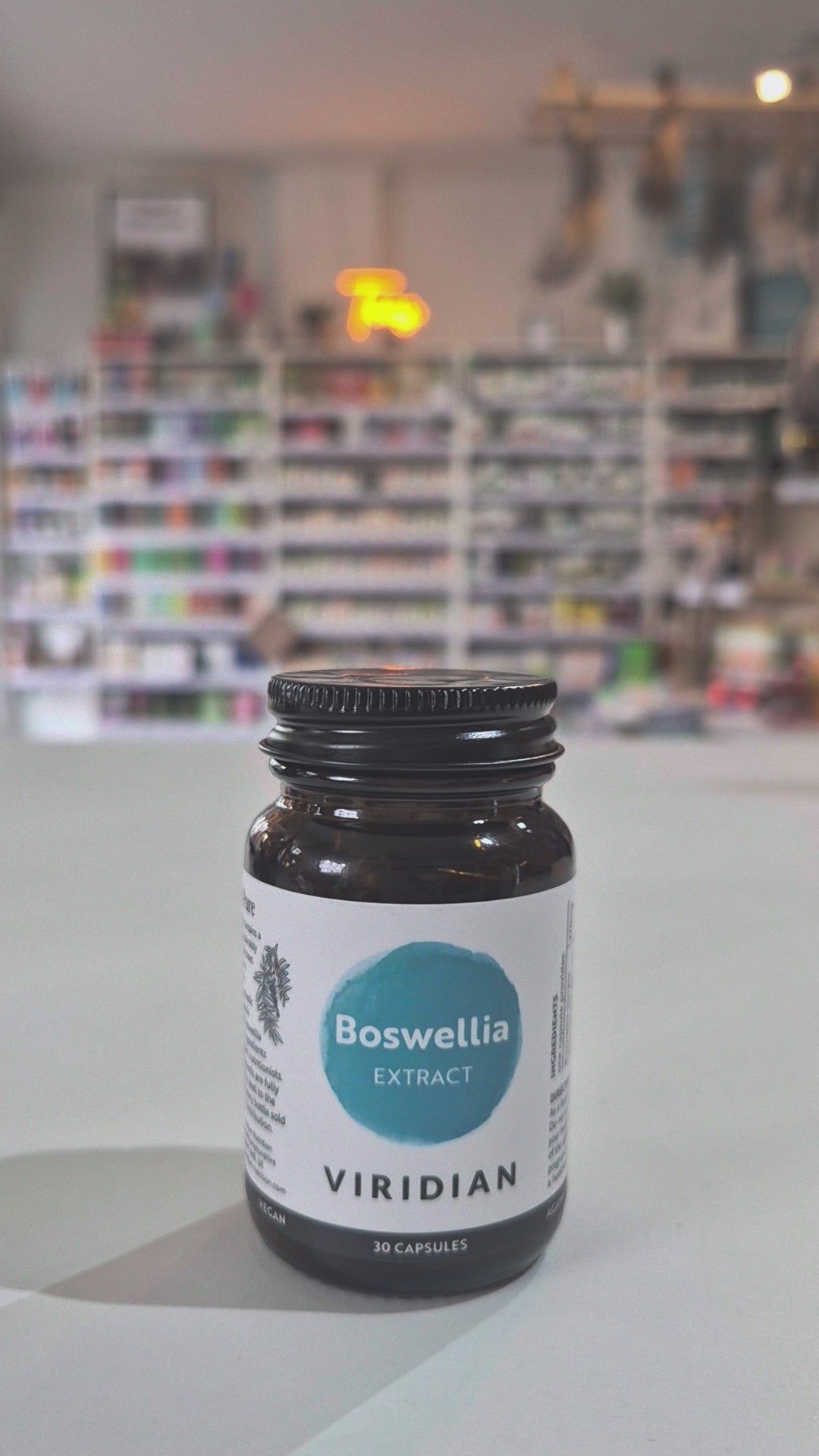 Bottle of Viridian Boswellia on a white surface with a blurred background