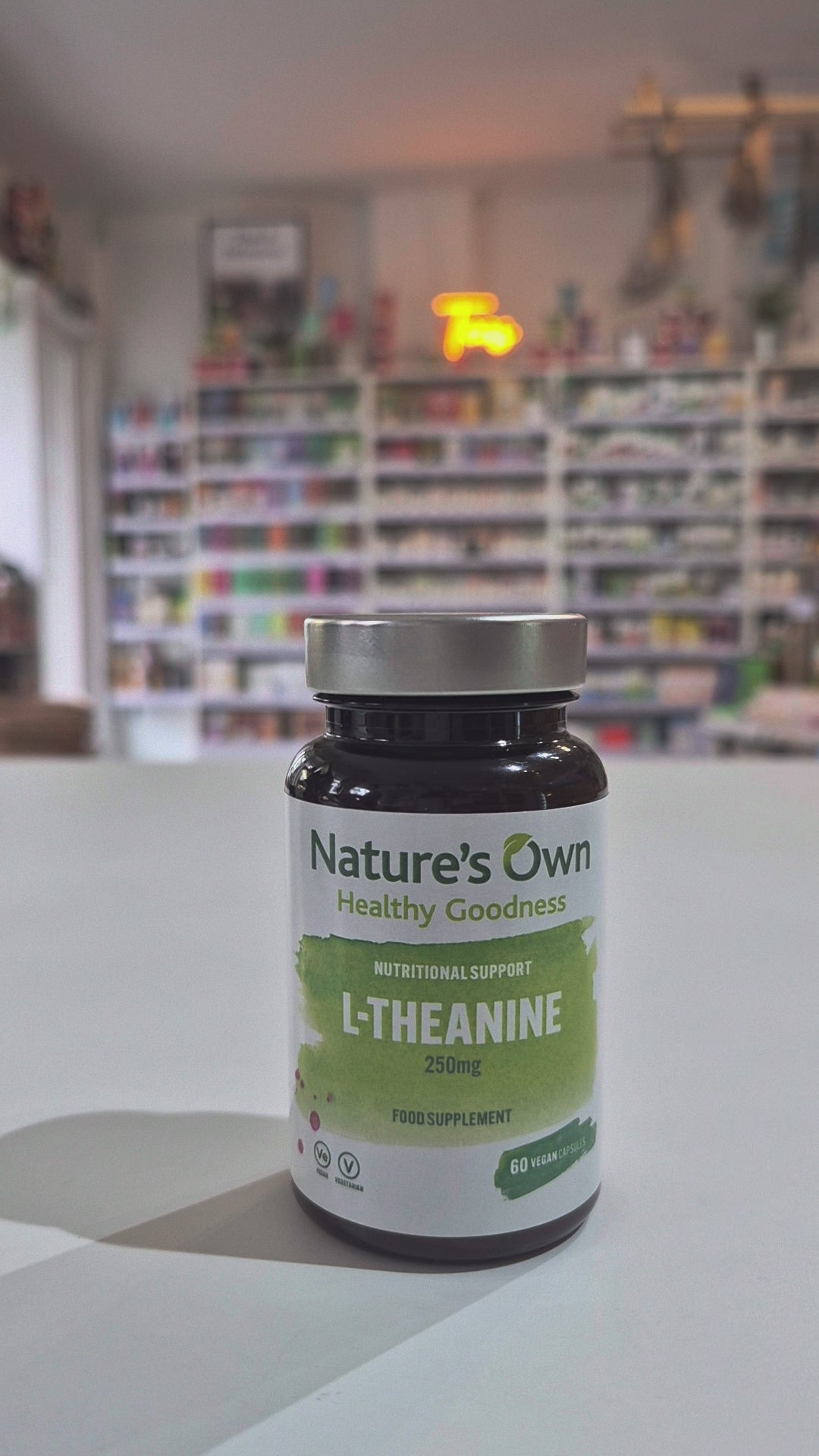 A bottle of Nature's Own L-Theanine, a nutritional supplement intended to support relaxation and brain function in a shop. 