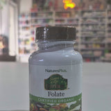 NaturesPlus Folate supplement bottle on a Video in a shop background