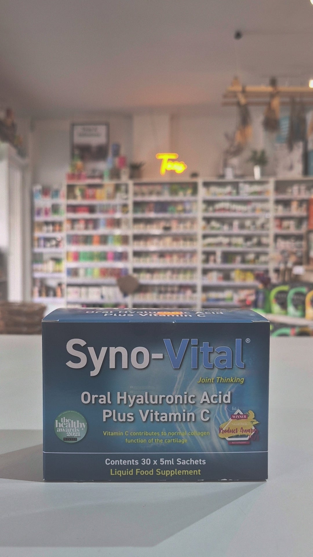 A box of Syno-Vital Joint Thinking Oral Hyaluronic Acid Plus Vitamin C sachets, with a blue color scheme and an illustration of a joint. The box states it contains 30 x 5ml sachets and is a liquid food supplement video
