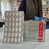 Box of Pharma Nord Bio Calcium + D3 - 150 Tabs with tablets displayed in front. Person holding a supplement box with a visible brand name in an indoor setting