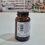 Amber glass bottle with a label on a white surface, blurred store shelves in the background