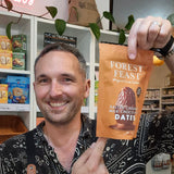 Man holding a package of Forest Feast salted caramel milk chocolate dates in a store setting.