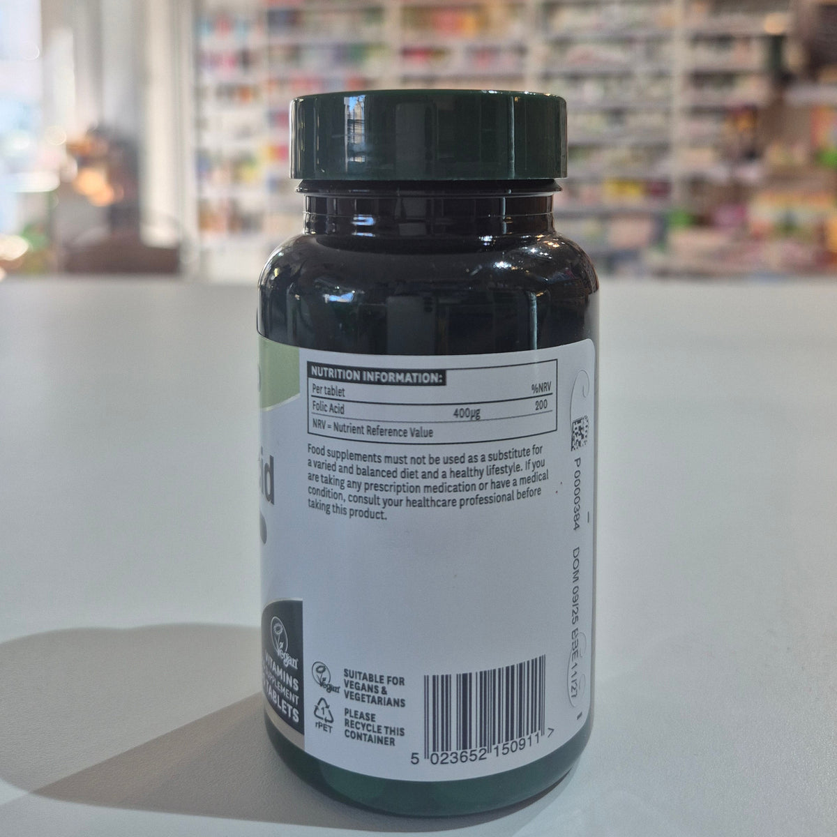 Bottle with a label on a white surface, blurred background