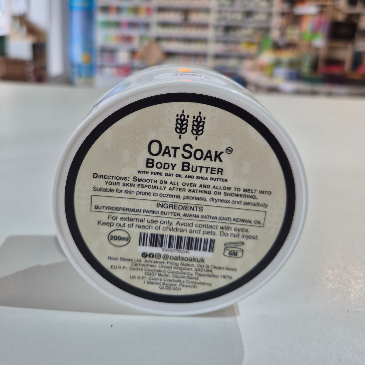 Oat Soak body butter container with label in a store setting