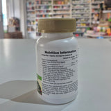 Close-up of a supplement bottle with nutrition information label, blurred store interior in the background