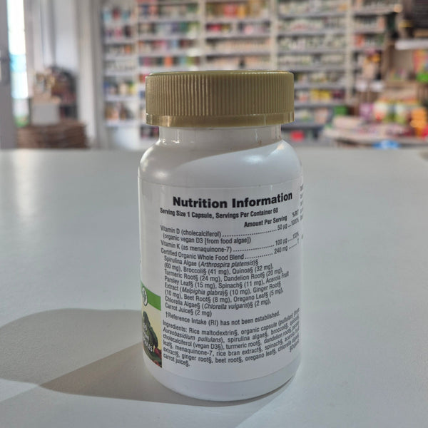 Close-up of a supplement bottle with nutrition information label, blurred store interior in the background