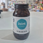 Jar of Viridian Joint Complex on a white surface with a blurred store background