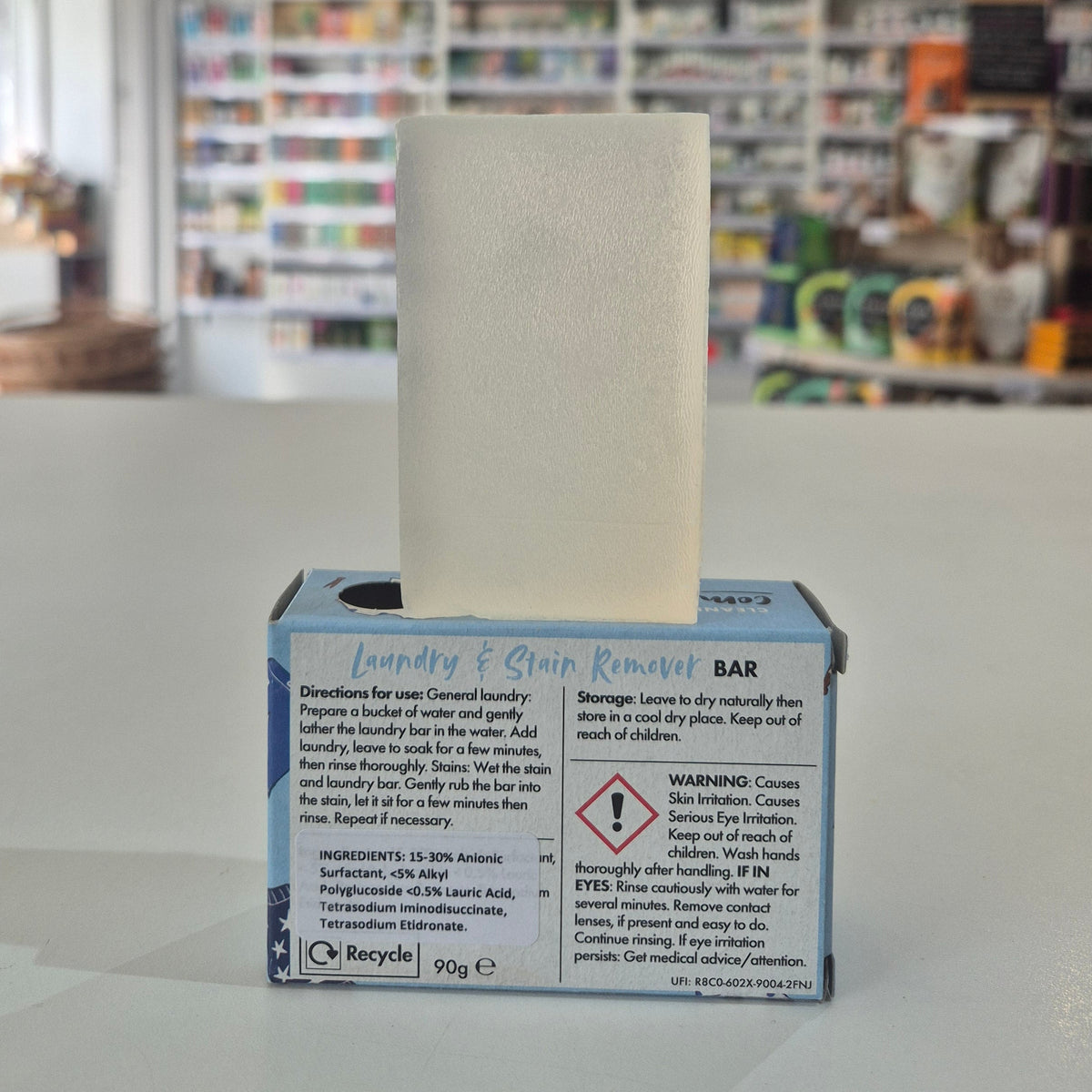 Bar of soap in a box with text on a blurred store background