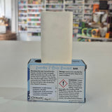 Bar of soap in a box with text on a blurred store background
