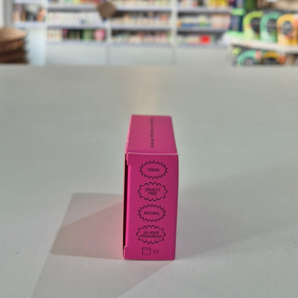 Pink deodorant refill box labeled 'fussy' on a gray surface with a blurred store background, saying vegan, Natural and Cruelty Free