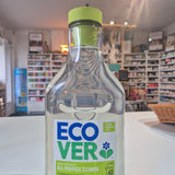 Clear bottle with green cap and Eco Ver label on a blurred indoor background
