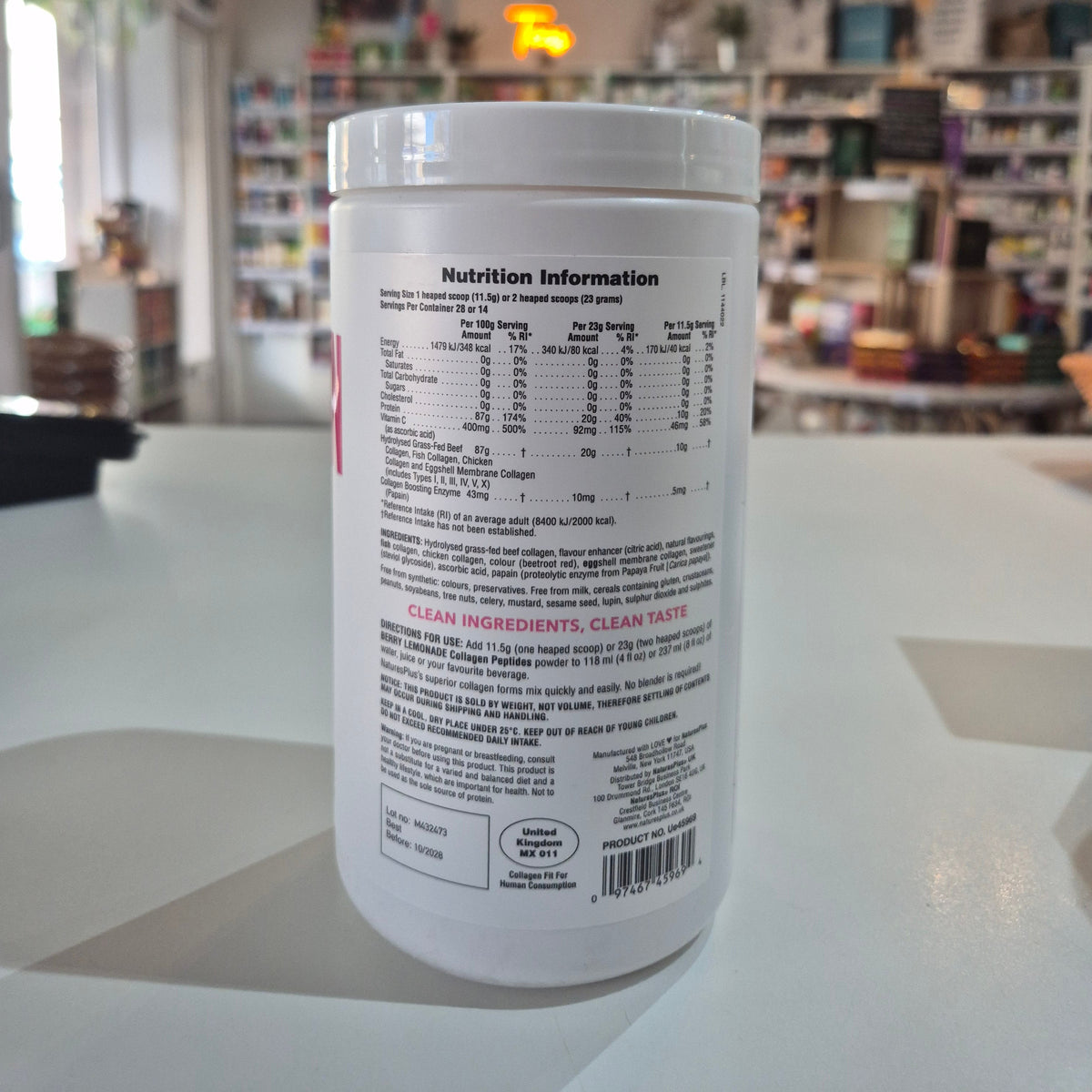 White supplement container with nutrition label on a blurred store background