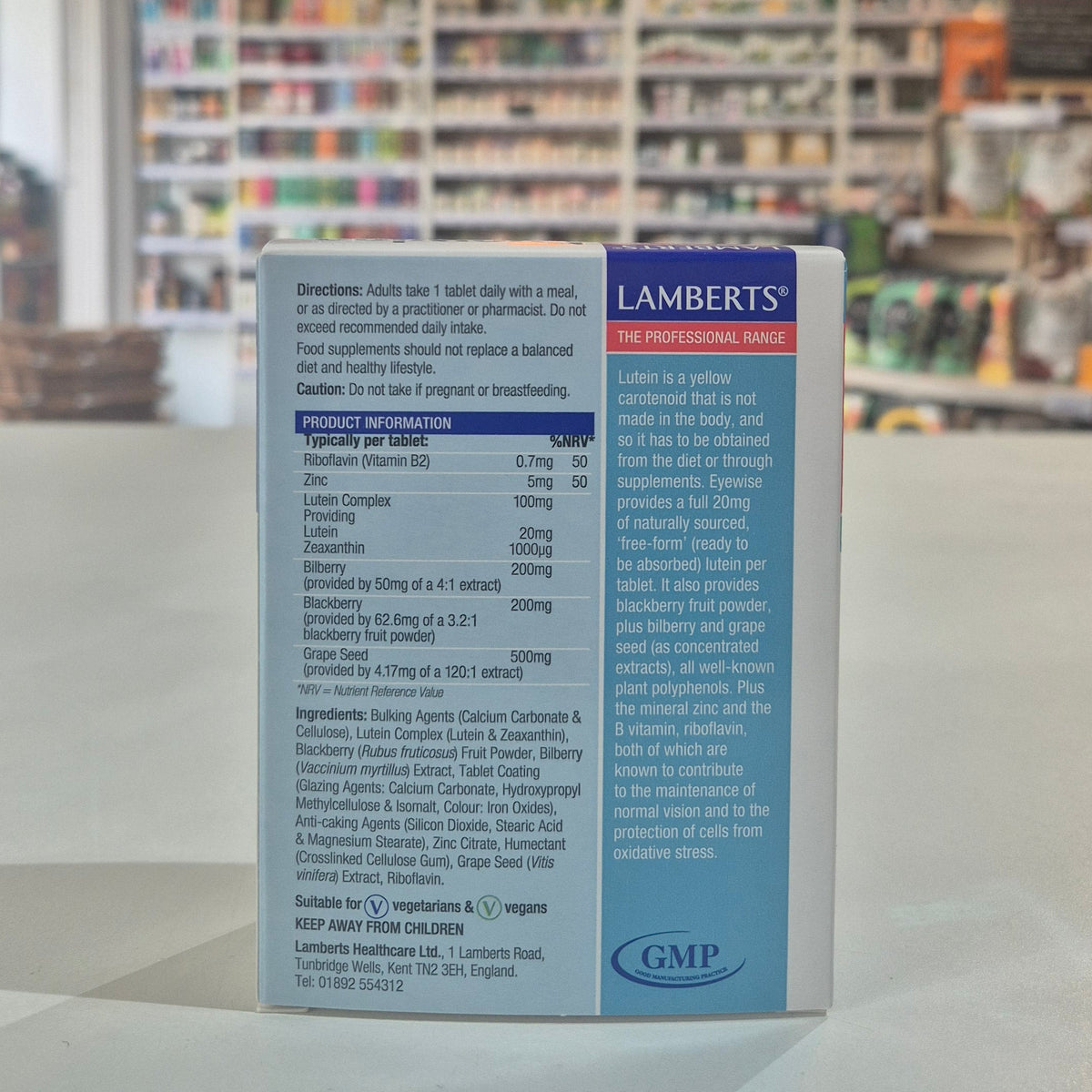 Lamberts supplement box with product information on a blurred store shelf background
