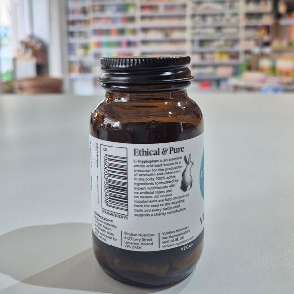 Bottle with label on a white surface, blurred background of shelves with products